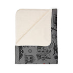 Folded Salem blanket corner showing the cream-colored sherpa underside and gray landmark print