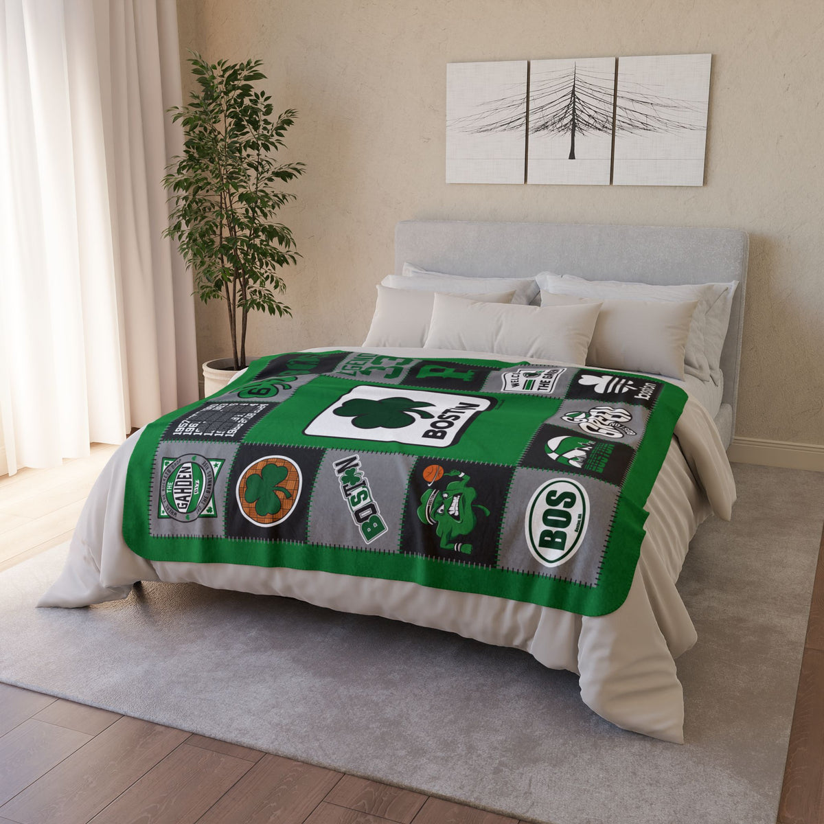 Green, black and gray Boston basketball fleece blanket displayed across a bed