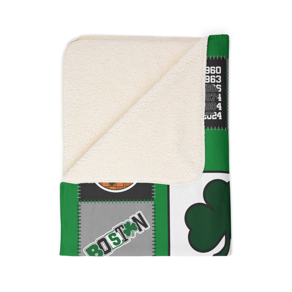 Folded Boston basketball blanket showing cream sherpa underside and green shamrock print