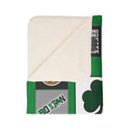 Folded Boston basketball blanket showing cream sherpa underside and green shamrock print
