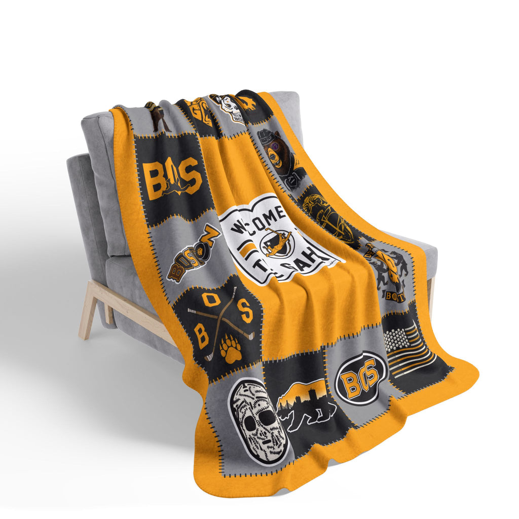 Gold Boston hockey patchwork-style fleece blanket draped over a gray chair