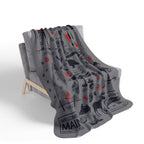 Gray Maine landmark and wildlife collage blanket with red accents draped over a chair