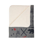 Folded Maine blanket showing its cream-colored sherpa underside beside the gray printed front
