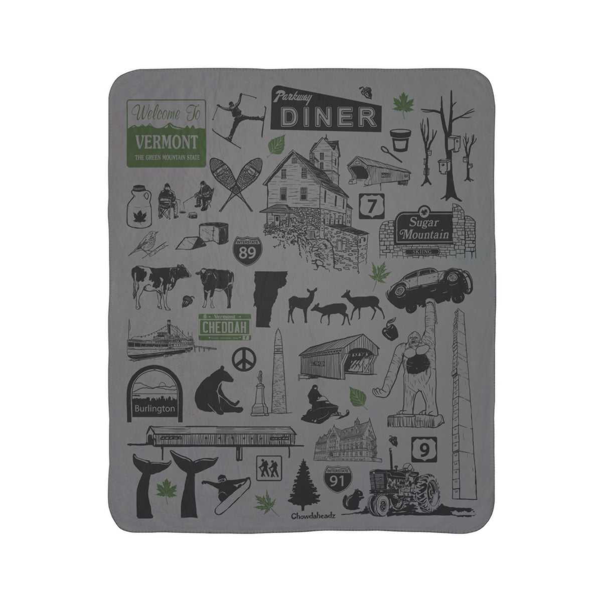 Vermont fleece sherpa blanket laid flat with black landmarks, maple syrup and wildlife illustrations and green accents on gray