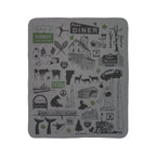 Vermont fleece sherpa blanket laid flat with black landmarks, maple syrup and wildlife illustrations and green accents on gray