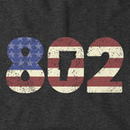 Close-up of charcoal Patriotic 802 hoodie design — area code and flag detail