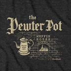 Close-up of Pewter Pot Muffin House lettering, pewter pot and brick fireplace on charcoal fabric