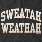 Close-up of cream-and-tan Sweatah Weathah lettering with stitch-style detailing on charcoal fabric