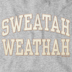 Close-up of cream-and-tan Sweatah Weathah lettering with stitch-style detailing on gray fabric