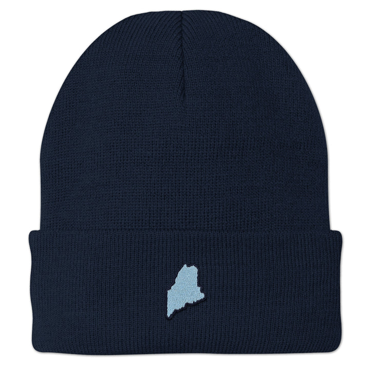 Front view of a navy cuffed knit hat with a small light-blue Maine-shaped patch outlined in dark thread
