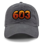 Front view of a charcoal Retro 603 New Hampshire dad hat with orange-and-red-striped numbers and a state silhouette in the zero