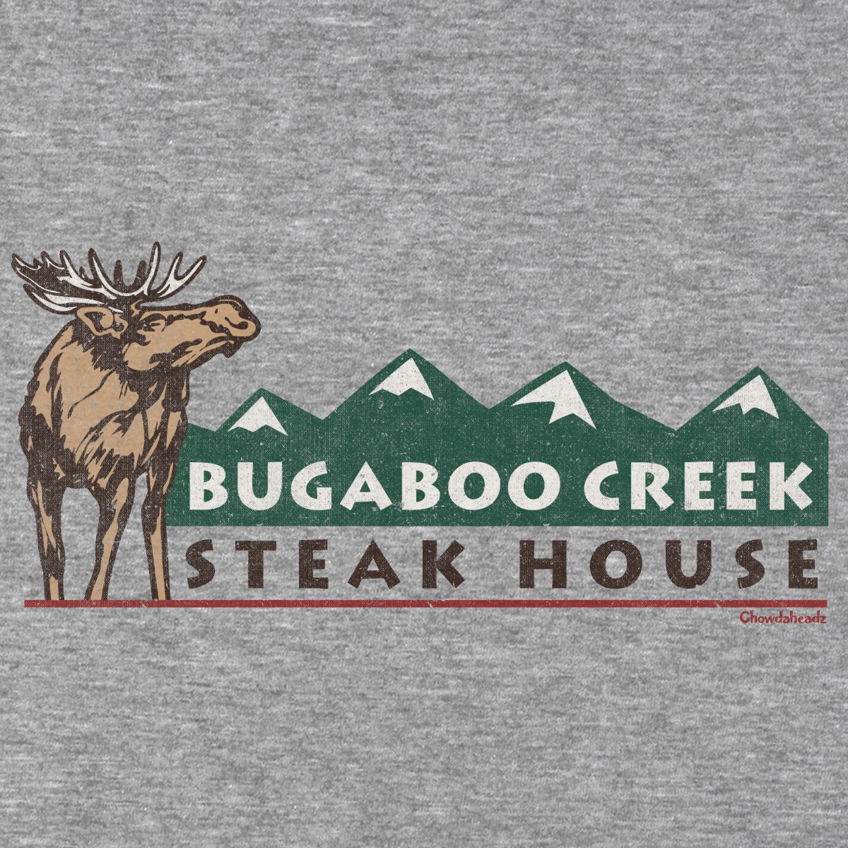 Close-up of the moose, green mountain peaks, and Bugaboo Creek Steak House lettering on gray fabric